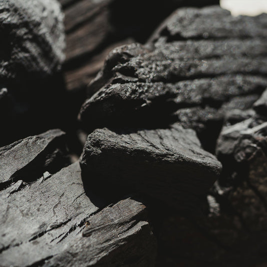 Close-up of dark gray charcoal with a blurred background
