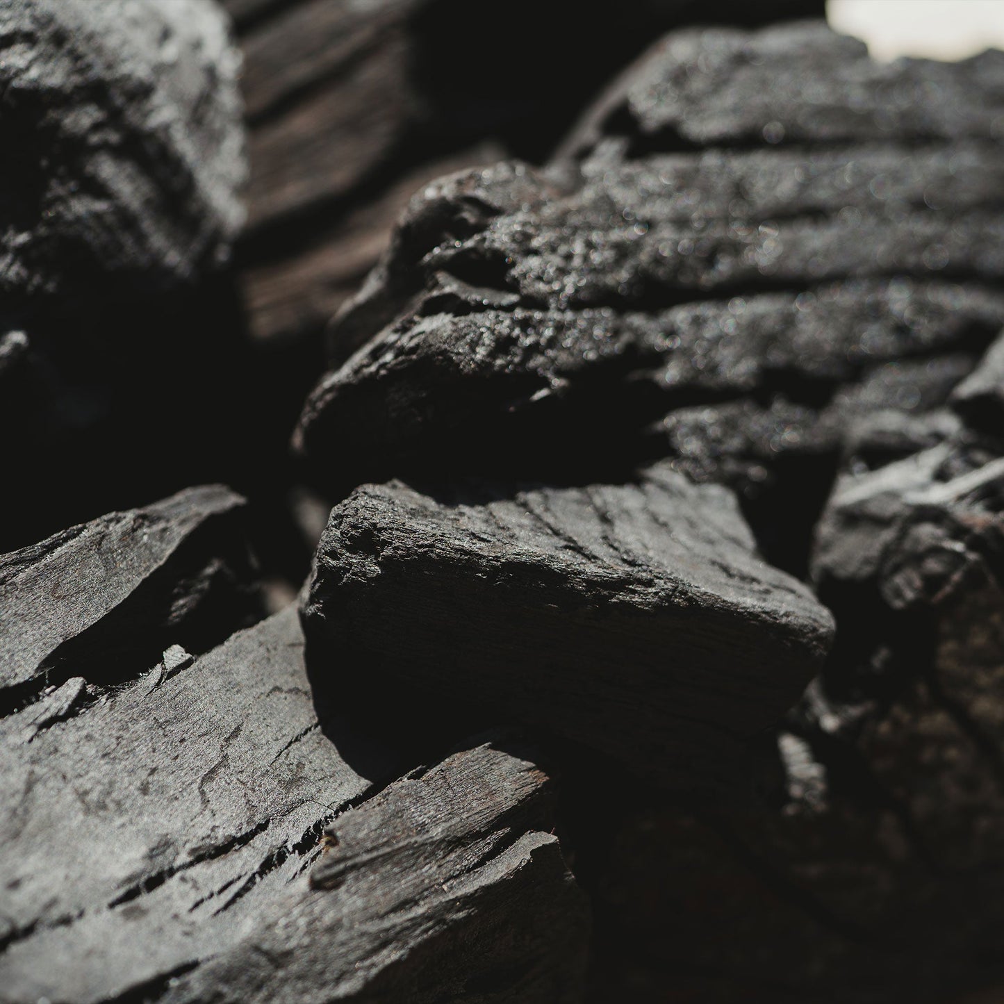 Close-up of dark gray charcoal with a blurred background