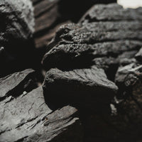 Close-up of dark gray charcoal with a blurred background