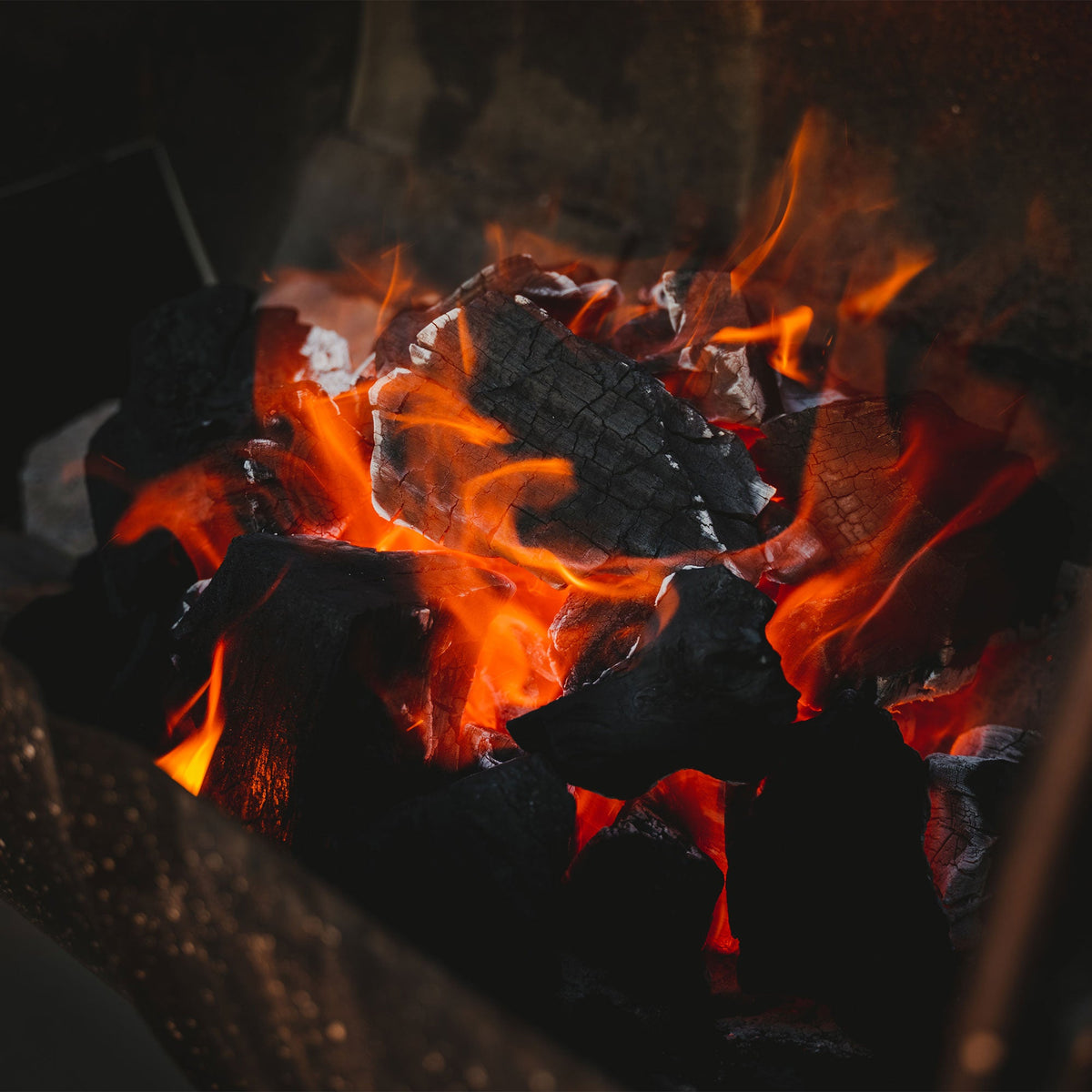 Close-up of burning wood with flames and glowing embers